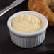 A bowl of Minerva Dairy unsalted butter with a croissant on a plate.