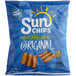 A blue bag of Sun Chips Original on a blue surface.