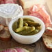A bowl of Les Trois Petits Cochons cornichon pickles with cheese and bread.