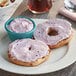 Two bagels with Lancaster County Farms Blueberry Cream Cheese Spread on a white plate.