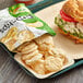 A tray with a sandwich and a bag of Popchips Sour Cream & Onion on a table.