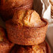 A basket filled with Bake'n Joy lemon poppy muffins on a table.