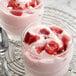 Sliced strawberries in a glass of yogurt.