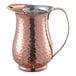 An Acopa hammered copper pitcher with a handle.