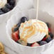 A bowl of fruit with Ghirardelli Vanilla Flavoring Sauce poured over it.