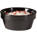 A black fluted melamine ramekin filled with red and white food.