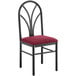 A black Lancaster Table & Seating Spoke Back chair with a red cushion