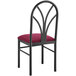 A Lancaster Table & Seating black metal chair with a merlot fabric seat detached.