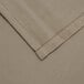 A beige rectangular cloth table cover with a white hem.