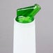 A white plastic Carlisle Store 'N Pour bottle with a green spout and cap.