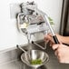 A person using a Nemco Green Onion Slicer Plus to chop green onions.