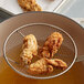 Fried chicken wings in a pan with J.O. Oyster and Fish Breader.