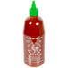 A bottle of Huy Fong Sriracha hot sauce with a green lid.