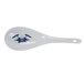 A white spoon with a blue flower design on the handle.