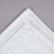 A close up of a white Oxford Platinum bath mat with a dobby twill hem.