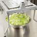 A Vollrath Redco Lettuce King chopping a bowl of lettuce on a metal surface.