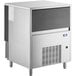 A large silver rectangular object with a black door: Manitowoc UNF0300A undercounter ice machine.