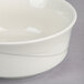 A white Oneida Espree china bowl with a wavy design.