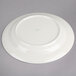 A Oneida cream white china plate with a green rim.