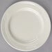A Oneida Espree cream white China bread and butter plate with a wavy design.