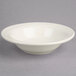 A Oneida cream white china fruit bowl with a rim on a gray surface.