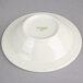 A white Oneida china fruit bowl with a green logo.