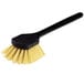 A close-up of a black Carlisle Sparta utility/pot scrub brush with a yellow handle.