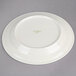 A white Oneida Espree china plate with green writing on it.