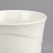 A close up of a cream white Oneida Espree bouillon cup with a wavy design.