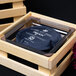 A wooden crate with a black Frilich plastic cooling plate display set inside.