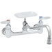 A chrome T&S wall mount pantry faucet with soap dish and two handles.
