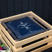 A Frilich RB560 square plastic cooling plate in a blue package on a wooden crate.