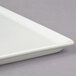 A white square Frilich china display plate.
