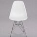 A white Flash Furniture plastic chair with metal legs.