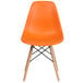 An orange Flash Furniture plastic accent chair with wooden legs.