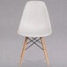 A white Flash Furniture plastic chair with wooden legs.