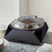 A black steel Rosseto chafer stand on a counter.