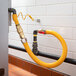 A yellow hose connected to a metal pipe with black and silver connectors.