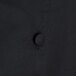 A close up of a black Chef Revival chef coat with buttons.