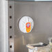 An Arm & Hammer Fridge Fresh air filter on a refrigerator door in a kitchen.
