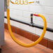 A yellow Regency gas connector hose attached to a pipe.