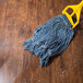 A yellow mop with a blue cloth cleaning a wood floor.