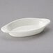 A white oval shaped dish with a handle.