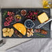 A Tablecraft rectangular faux slate melamine display tray with cheese, meat, crackers, and blueberries on it.