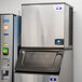 A large silver Manitowoc air cooled ice machine with a black lid.