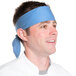 A man wearing a light blue chef neckerchief on his head.