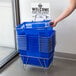 A person holding a Regency Blue plastic grocery shopping basket.