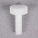 A True Nylon Thumbscrew with a nut on a gray surface.