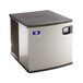 A silver and black Manitowoc water cooled ice machine with a blue logo on the lid.