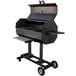A black R & V Works Smokin' Cajun barbecue grill on wheels with a lid.